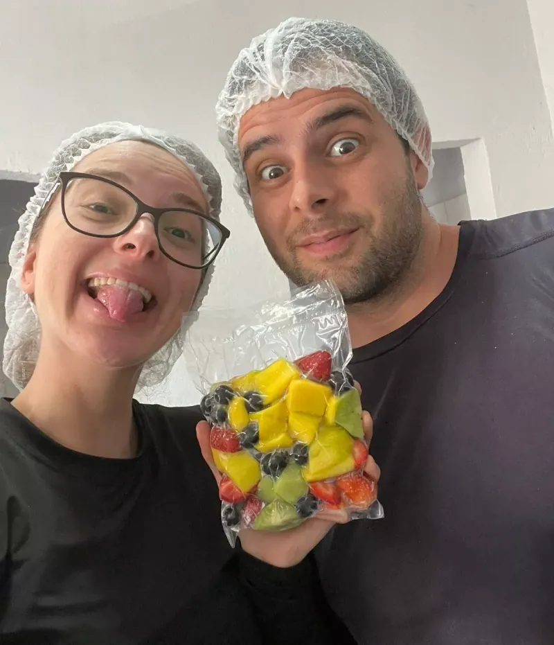 Gustavo e Giovana de touca segurando um pacote de picadinho